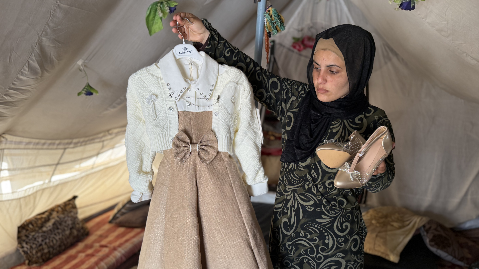 Ola Rihan holds a dress and shoes she bought for her daughter's uncle's wedding before she was killed